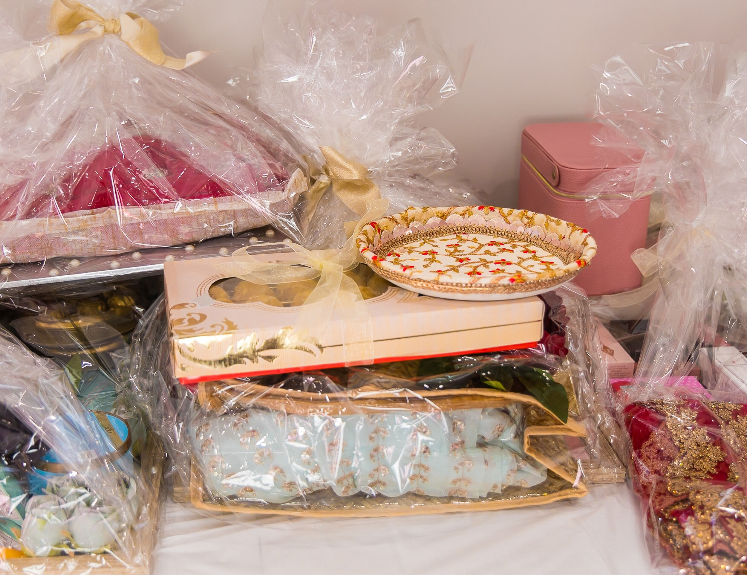 Gift set with sarees, crockery, and mithai beautifully packed for an Indian wedding.